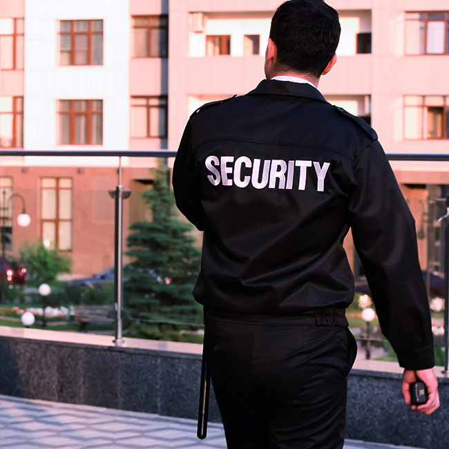 security guard holding a walkie talkie while patroling a buildiing battle creek mi